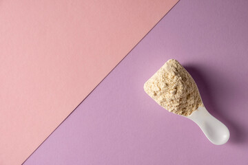 Spoon with protein on colored background.