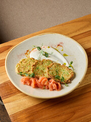 Exquisite presentation of zucchini fritters topped with smoked salmon and microgreens for fine dining
