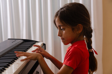 An eight-year-old girl playing an electric piano.