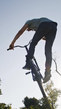 Amateur bmx rider in headwear performing risky move