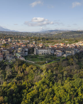 Aerial view of the historic Castello Filangieri, a majestic jewel amidst the verdant embrace of trees, its stone facade reflecting the soft light, Lapio, Irpinia, Campania, Italy.