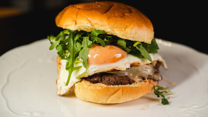 Nutritious burger with egg, fresh arugula (rocket), and lean beef on a whole wheat bun. High-protein, balanced meal for fitness and clean eating lifestyles.