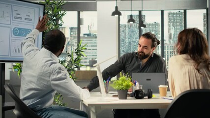 Diverse business colleagues gathered around laptops working on project tasks for development. Office environment promotes synergy, teamwork and insight through analytics. Camera B. - Powered by Adobe