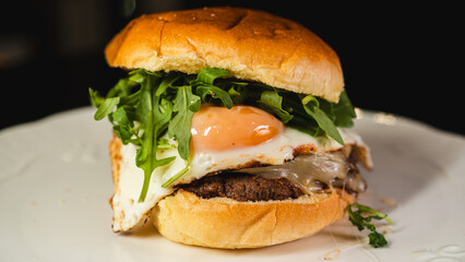 Nutritious burger with egg, fresh arugula (rocket), and lean beef on a whole wheat bun. High-protein, balanced meal for fitness and clean eating lifestyles.