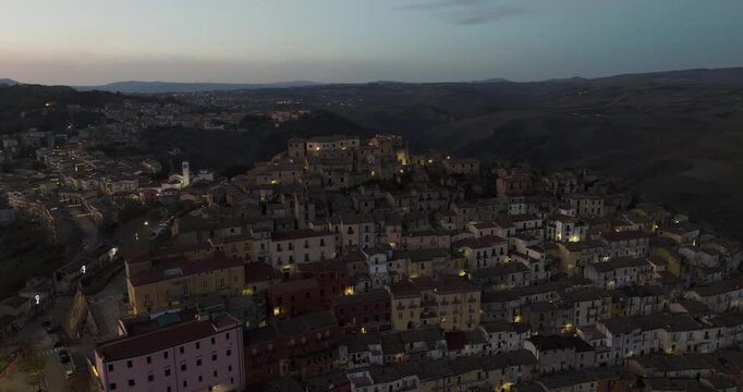 Aerial view of city lights twinkling amidst the dark landscape, creating a mesmerizing contrast between the illuminated buildings and the night, Calitri, Irpinia, Italy.