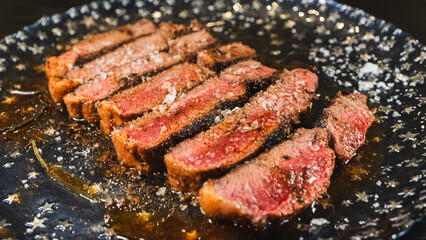 Sliced rare rump steak on a plate, revealing pink interior under a beautiful golden crust. Topped with salt, juicy and perfectly cooked. Gourmet meat presentation.