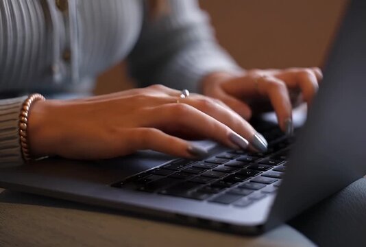 Woman's hands typing quickly on laptop keyboard for business or online education video sequence