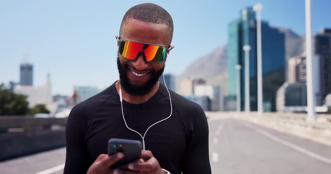 Technology, fitness and black man on street for workout, streaming music and check start time for run. Sunglasses, earphones and happy athlete with smart watch for exercise progress, phone or space - Powered by Adobe