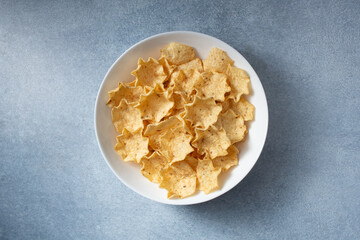 A top down view of a bowl of tortilla chips scoops.