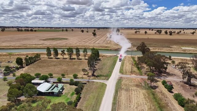 Road train travels along a dusty rural dirt road
