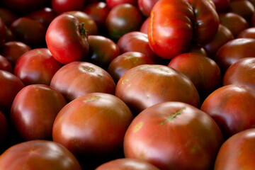 A view of a pile of purple boy tomatoes, seen at the farmers market.