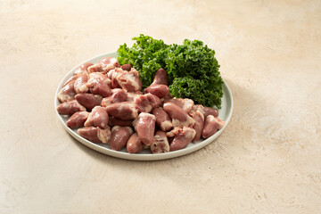 A view of a plate of raw chicken hearts.