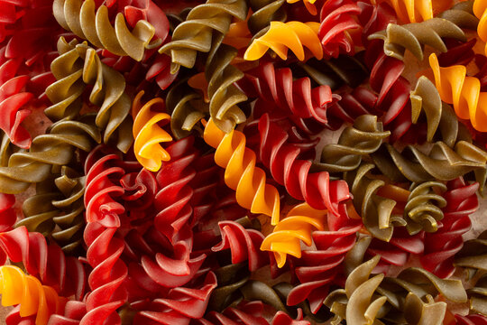 A top down view of a pile of rainbow rotini, as a background.