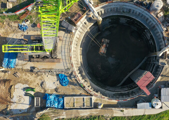 Aerial view of deep shaft excavation with crane and machinery