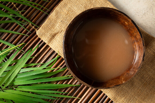 A top down view of a bowl of kava in a coconut bowl.