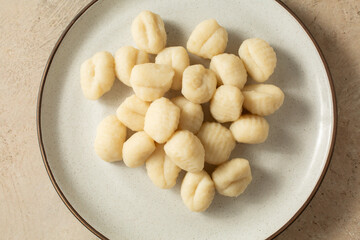 A top down view of a plate of cooked gluten-free gnocchi.