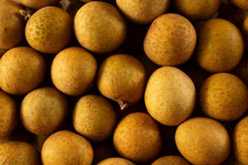 A top down view of a pile of longan, as a background.