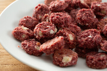 A closeup view of a pile of gluten-free, dairy-free soft baked mini red velvet cookies, on a plate.