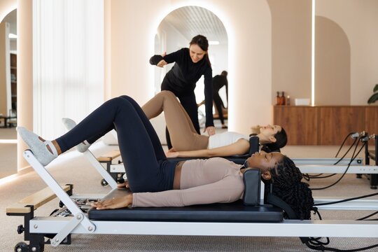 Side view of trainer showing woman how to do exercise during class