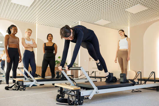 Group of women looking at female trainer teach them to do exercise