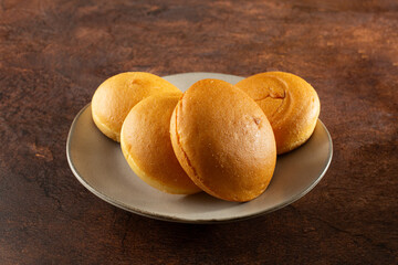 A view of some dairy-free, gluten-free brioche buns, on a plate.