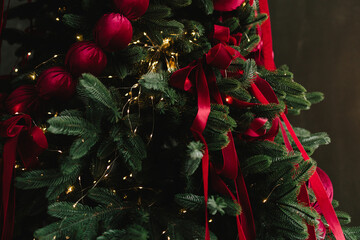 Girl arranging ornaments on a sparkling Christmas tree.