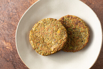 A top down view of some mushroom patties, on a plate.