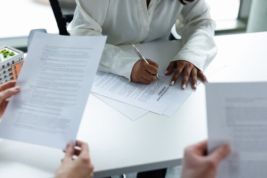 Agent signature purchase agreement while couple clients read document