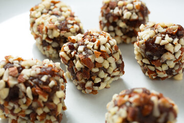 A closeup view of some almond date rolls, on a plate.