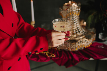 Sparkling champagne in hands above Christmas table decor.