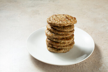 A view of a pile of chicken sausage patties, on a plate.