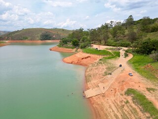 Vista do alto a seca da represa cercada de vegeta&ccedil;&atilde;o e natureza com cores vibrantes.