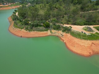 Vista do alto a seca da represa cercada de vegeta&ccedil;&atilde;o e natureza com cores vibrantes.