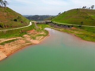 Vista do alto a seca da represa cercada de vegeta&ccedil;&atilde;o e natureza com cores vibrantes.