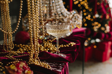 Holiday table with champagne glass, candles, and festive decorations.