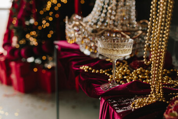 Champagne glass on festive table with candles and ornaments.