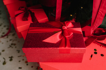 Festive red gifts under decorated Christmas tree for holiday joy.