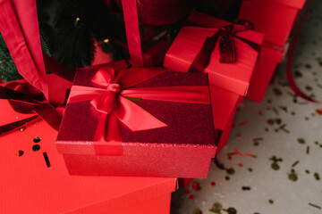 Christmas tree with red presents and sparkling holiday decorations.