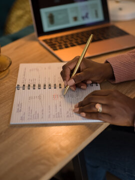 Woman writing numbers in notebook