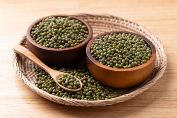 Mung bean seed in a bowl and spoon on wooden background, Asian food ingredient