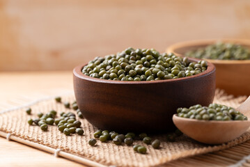 Mung bean seed in wooden bowl and spoon, Asian food ingredient