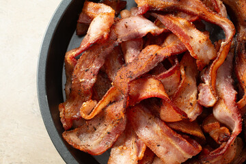 A top down view of a pan of thick cut bacon strips.