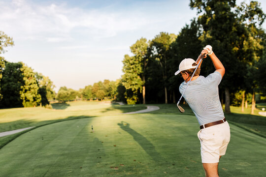 man golfing late in the afternoon