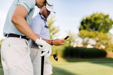 golfers use a golf app while playing 