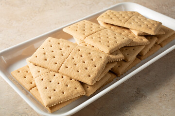 A view of a pile of gluten-free, dairy-free graham crackers, on a tray.