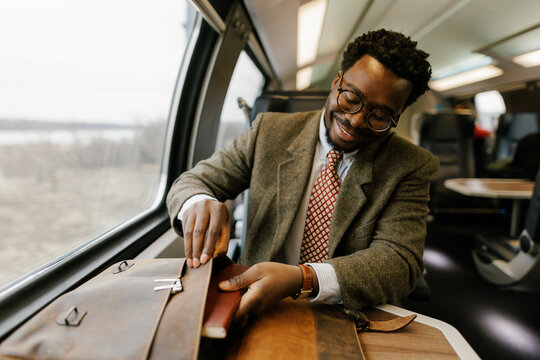Portrait of happy businessman commuting with train 