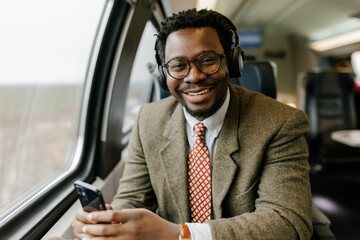 Professional Man on a Train Enjoying Music and Using Phone
