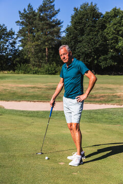 Senior Man Putting with Focus on a Golf Green