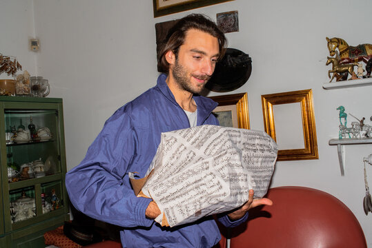 Person Carries Wrapped Gift in a Cozy Indoor Setting