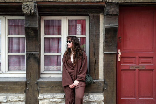 Woman by timber-framed house